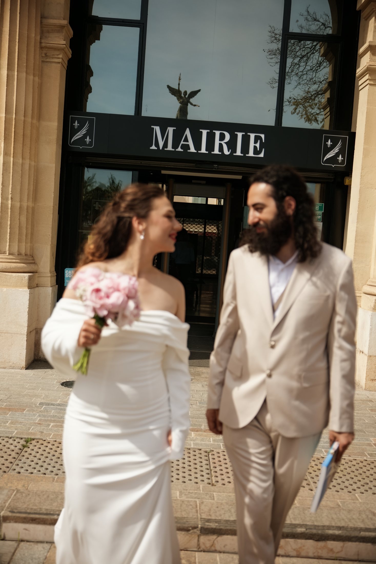 Les jeunes mariés se regardent devant l'hôtel de ville