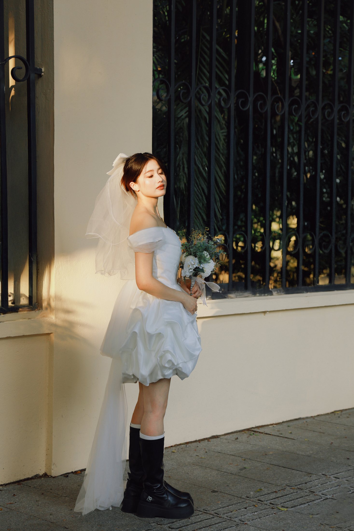 Portrait unique de la mariée à côté de la porte en fer forgé