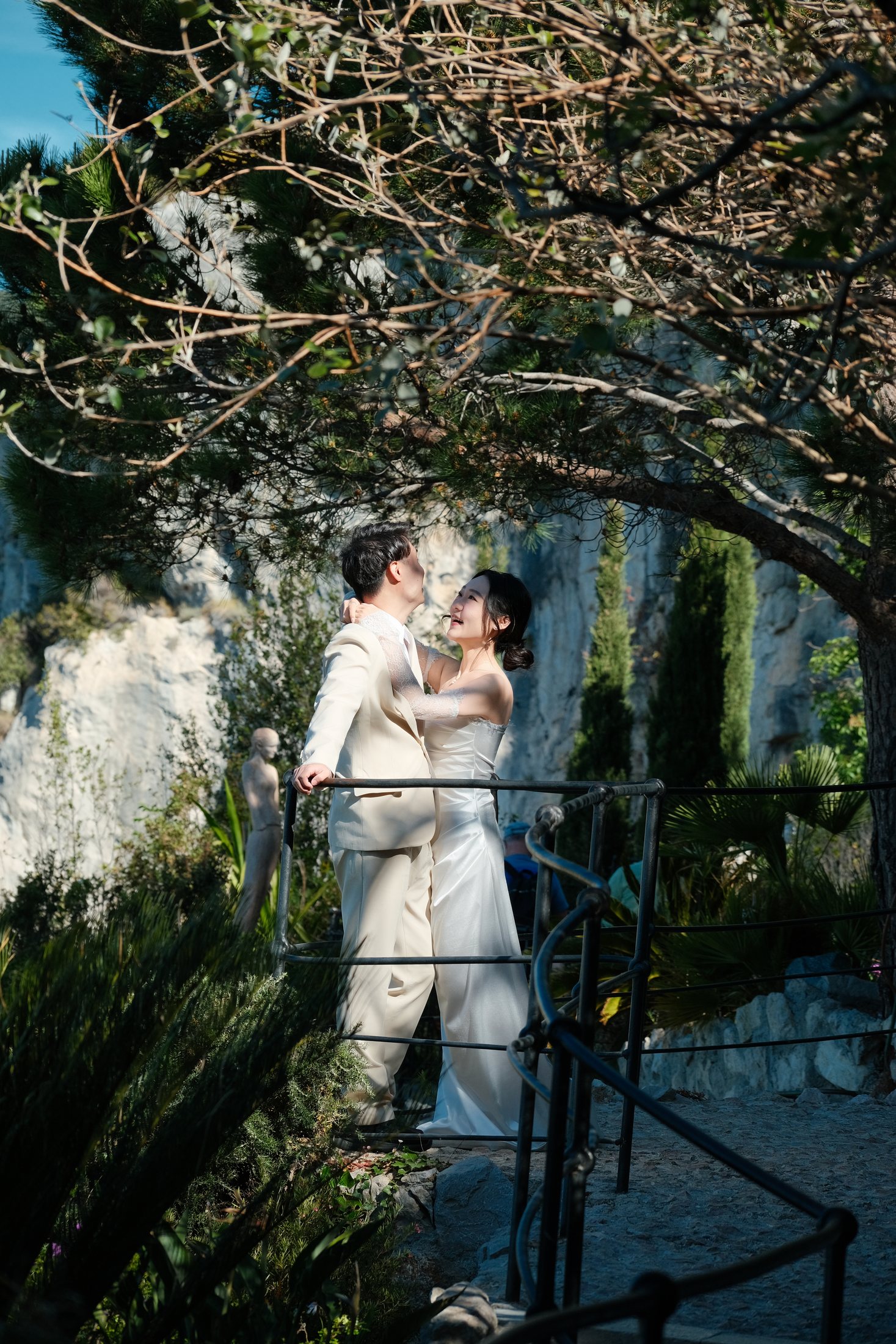 Couple prenant des photos sur les marches de pierre à l'ombre des arbres