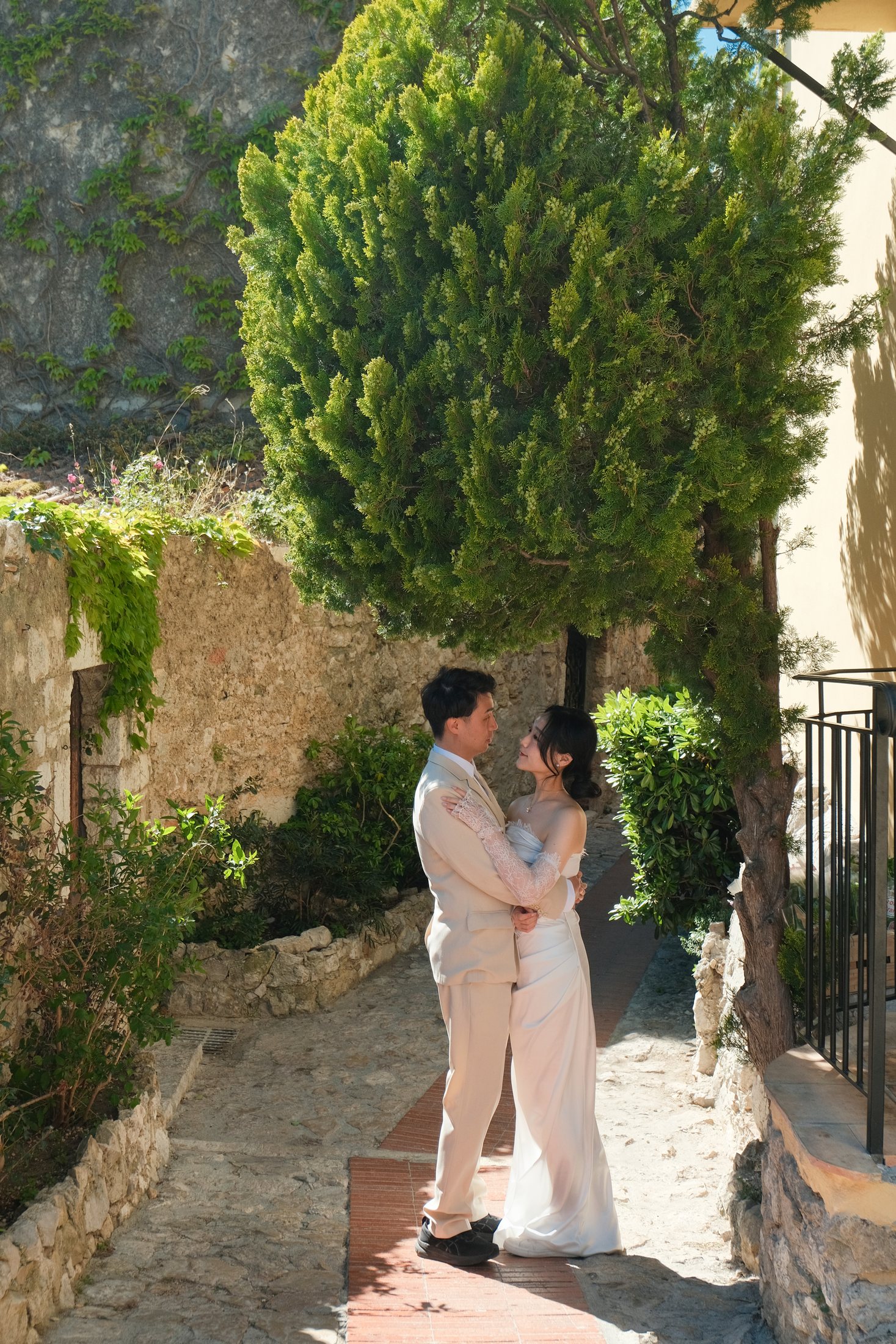 Couple prenant une photo intime dans une cour murale en pierre