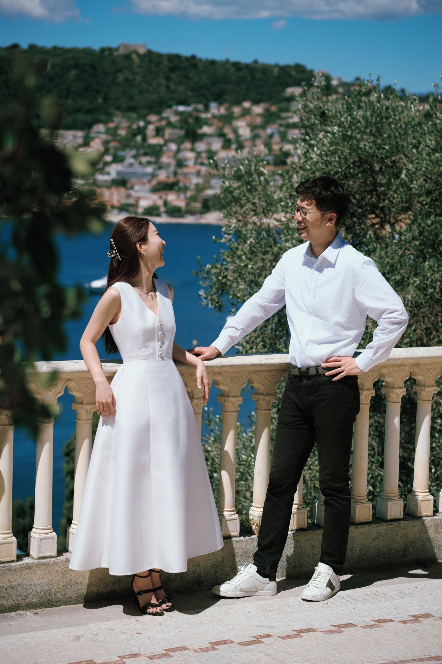 Couple se tenant la main sur une terrasse avec vue sur la mer