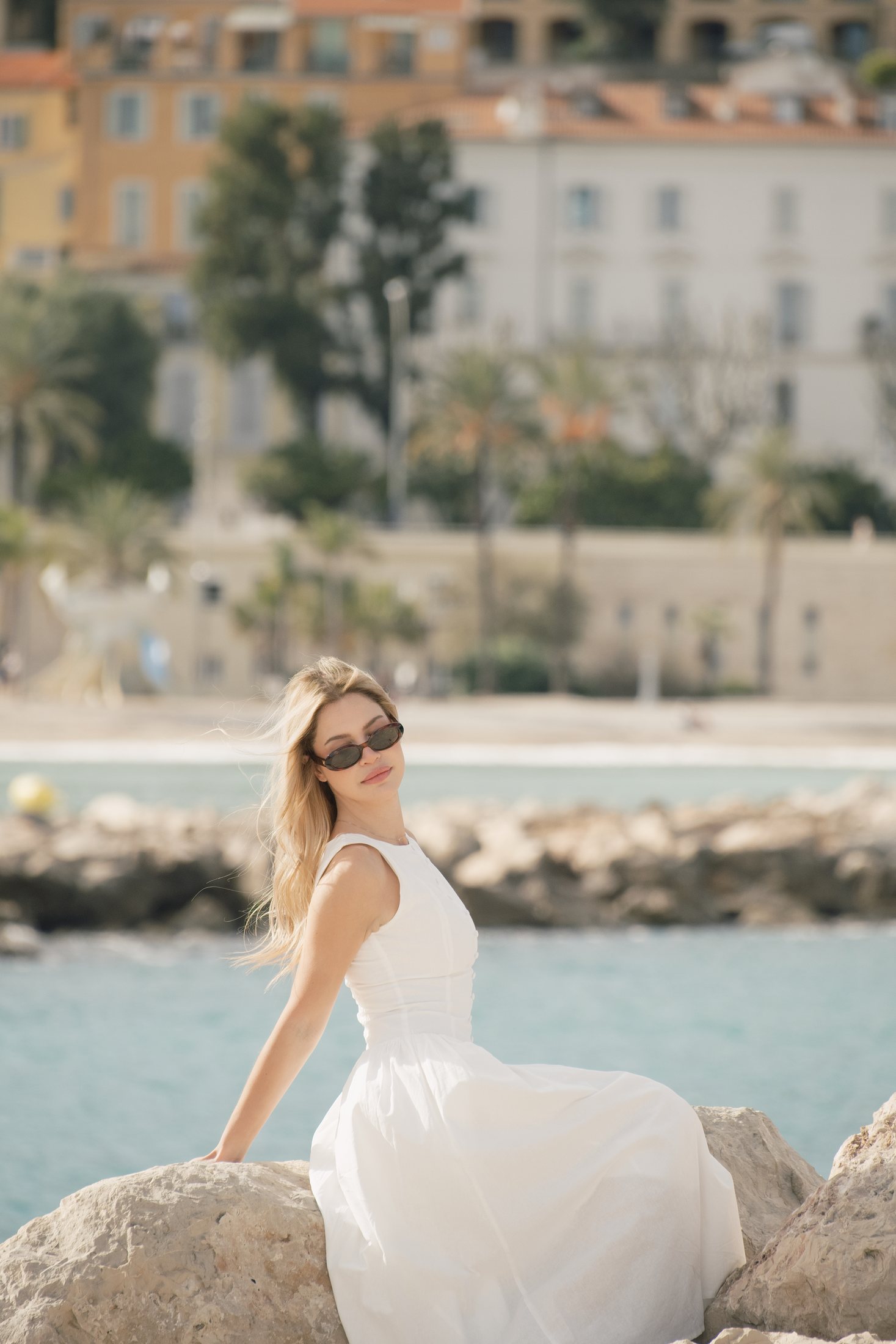Portrait d'une seule personne assise dans une robe blanche à la plage
